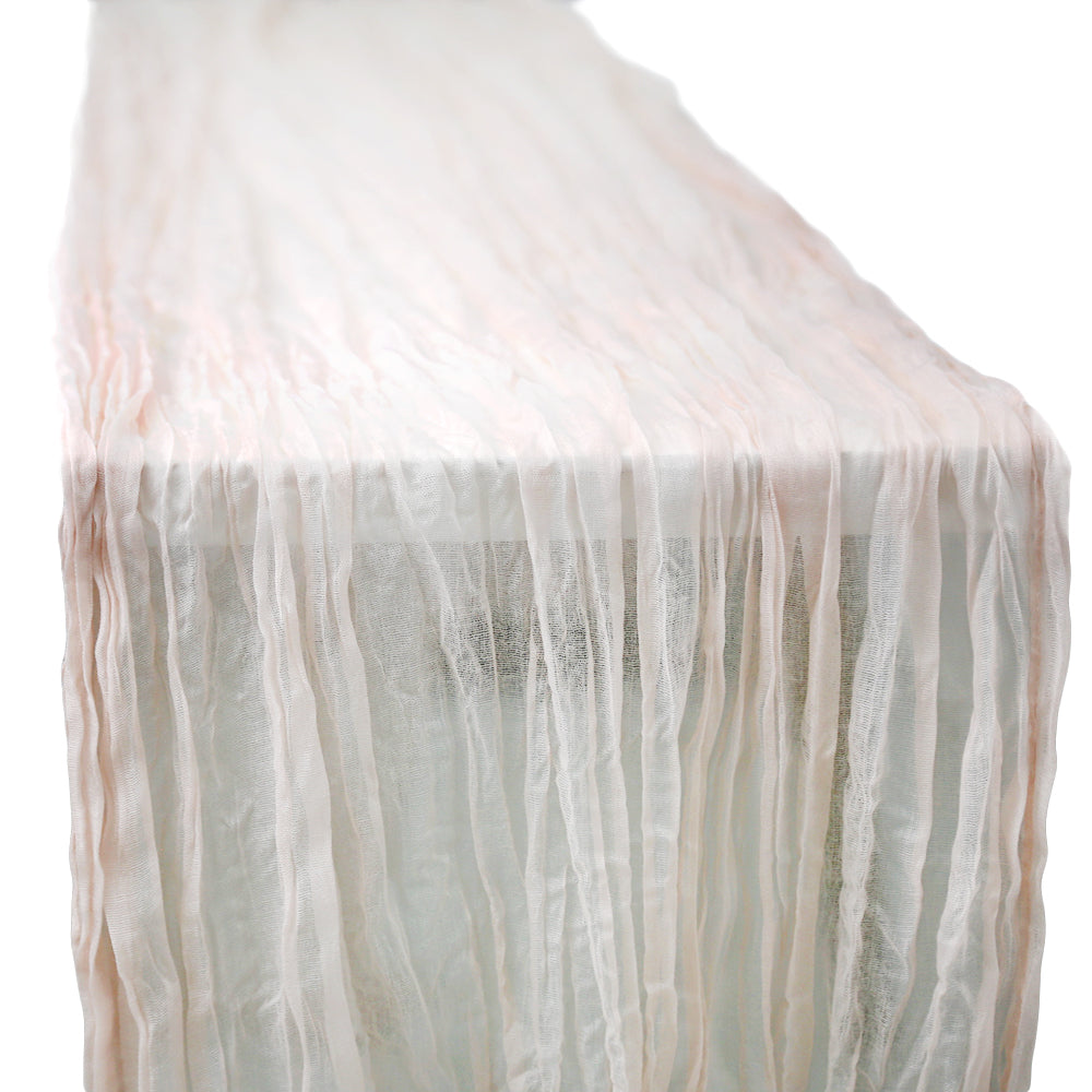 A gauze table runner in blush pink, featuring a delicate and airy fabric. The soft blush pink color adds a gentle and romantic touch to any table setting, perfect for enhancing a light and elegant ambiance.