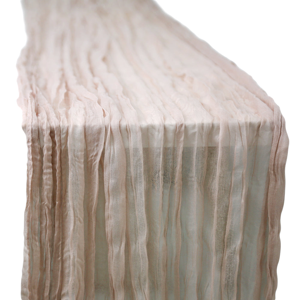 A gauze table runner in blush pink, featuring a delicate and airy fabric. The soft blush pink color adds a gentle and romantic touch to any table setting, perfect for enhancing a light and elegant ambiance.