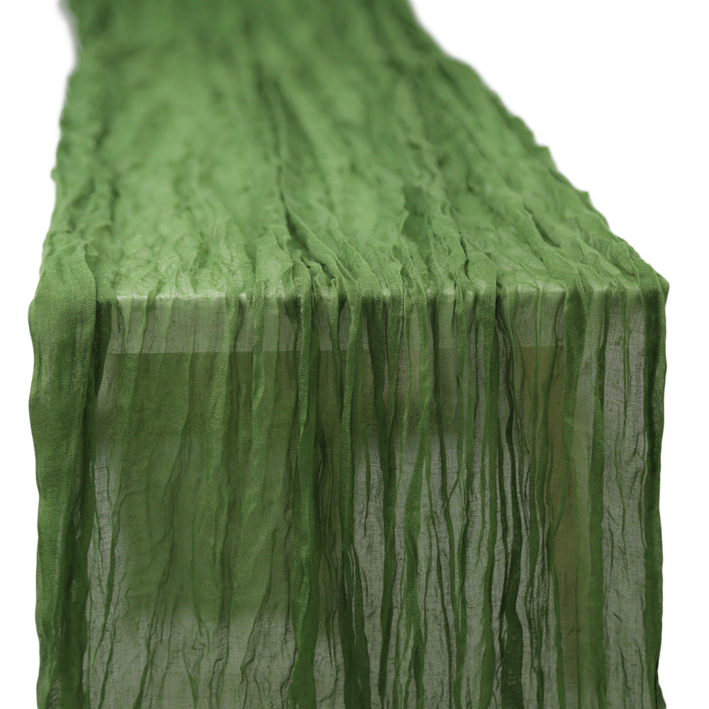 A gauze table runner in olive green, featuring a soft and textured fabric. The earthy olive green color adds a unique and sophisticated touch to any table setting, ideal for creating a natural and stylish atmosphere.