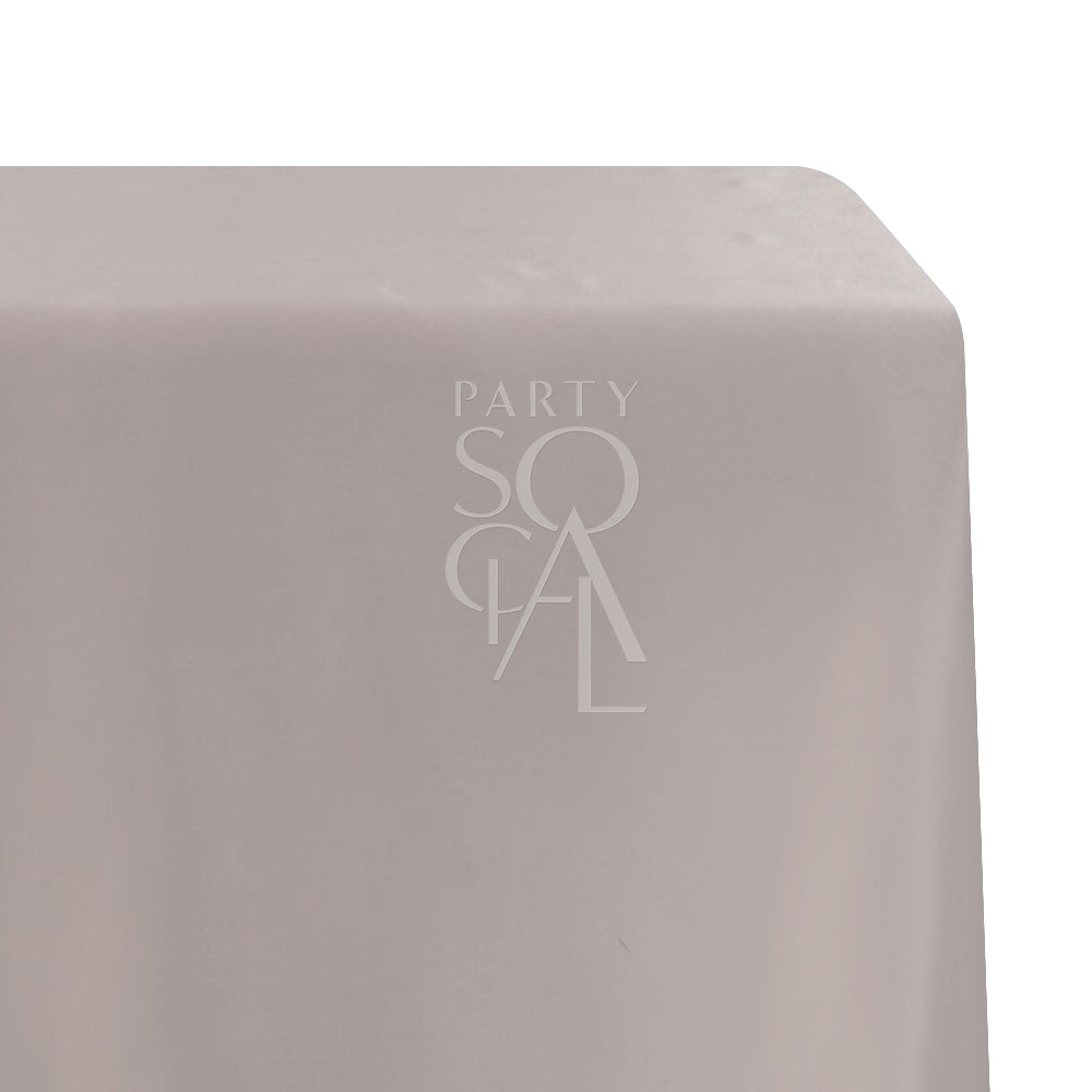 A rectangular satin tablecloth in soft blush pink, with a smooth and elegant texture. This delicate tablecloth enhances your dining area with a touch of refined charm, ideal for both everyday use and special occasions.