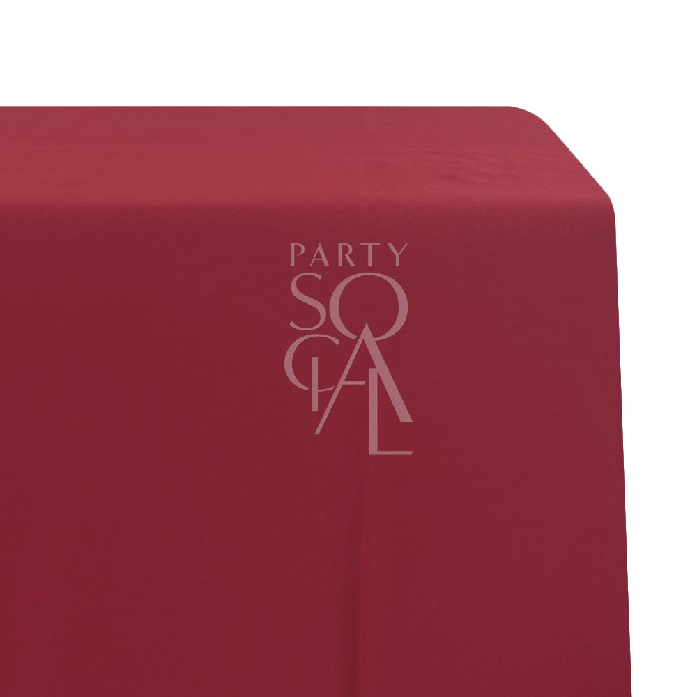 A rectangular satin tablecloth in deep burgundy, with a smooth and lustrous surface. This elegant tablecloth adds a bold and sophisticated touch to your dining area, ideal for formal dinners and special occasions.