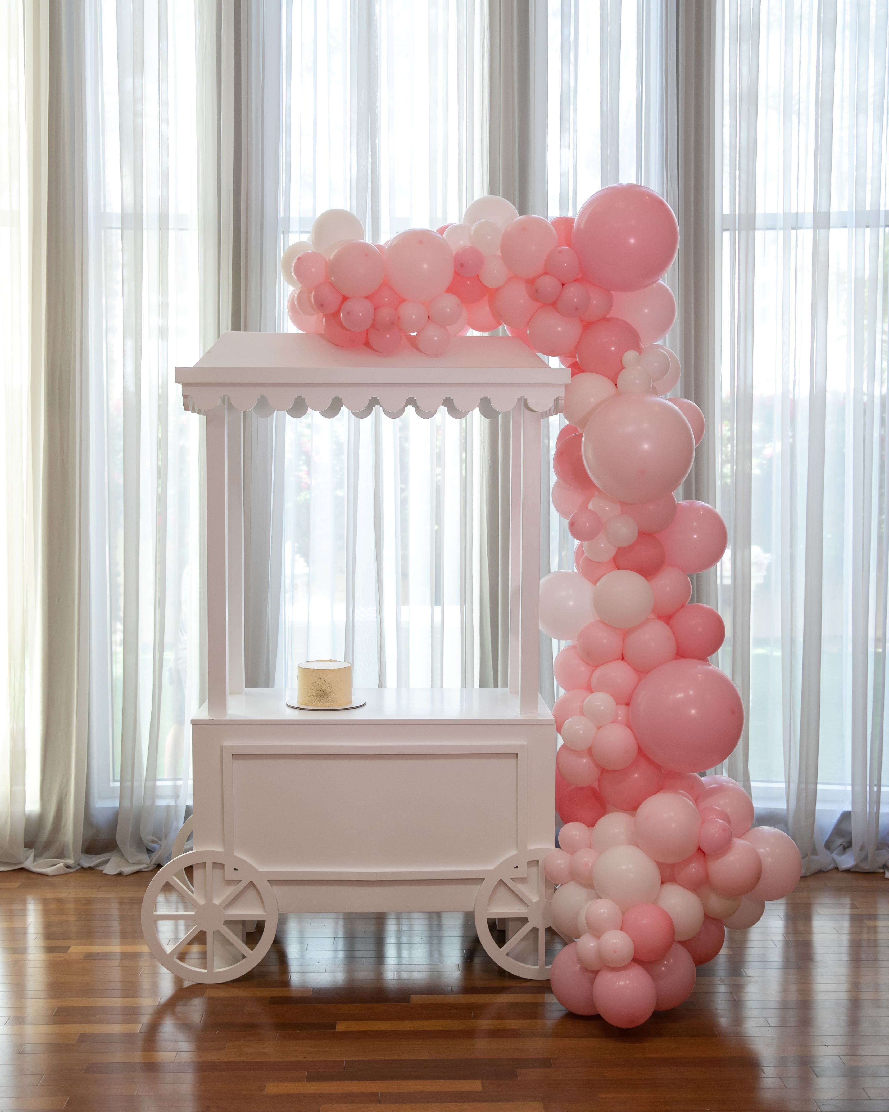 A white dessert cart, featuring a sleek and elegant design with multiple tiers for showcasing sweets and treats. The cart&