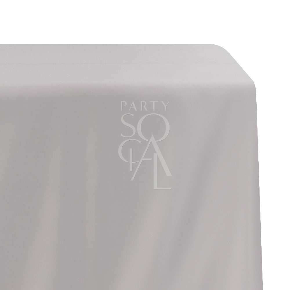 A rectangular satin tablecloth in muted dusty pink, featuring a luxurious and glossy finish. This sophisticated tablecloth adds a subtle touch of elegance and warmth to your dining setting, perfect for formal events and intimate gatherings.