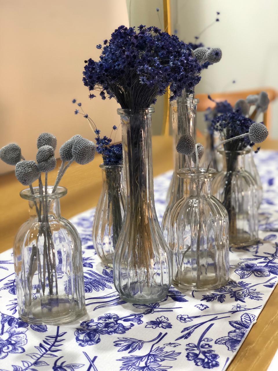 A set of mini clear vases featuring a simple and elegant design. These small, transparent vases are perfect for showcasing delicate flowers or small floral arrangements. Ideal for adding a touch of freshness and style to any table, shelf, or countertop, these vases complement various decor styles with their minimalist charm.