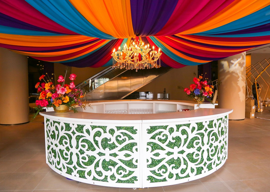 A curved bar unit featuring a sleek and modern design. This stylish bar unit has a smooth, curved structure, making it a perfect centerpiece for any event or home bar setup. Ideal for serving drinks and entertaining guests, adding a touch of sophistication and elegance to any setting.