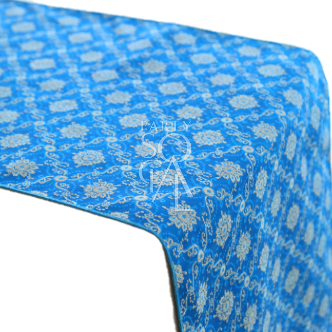A cushion cover in blue brocade, featuring a luxurious pattern with intricate textures and elegant detailing. This cover adds a sophisticated touch to any decor, perfect for enhancing sofas, chairs, or beds.