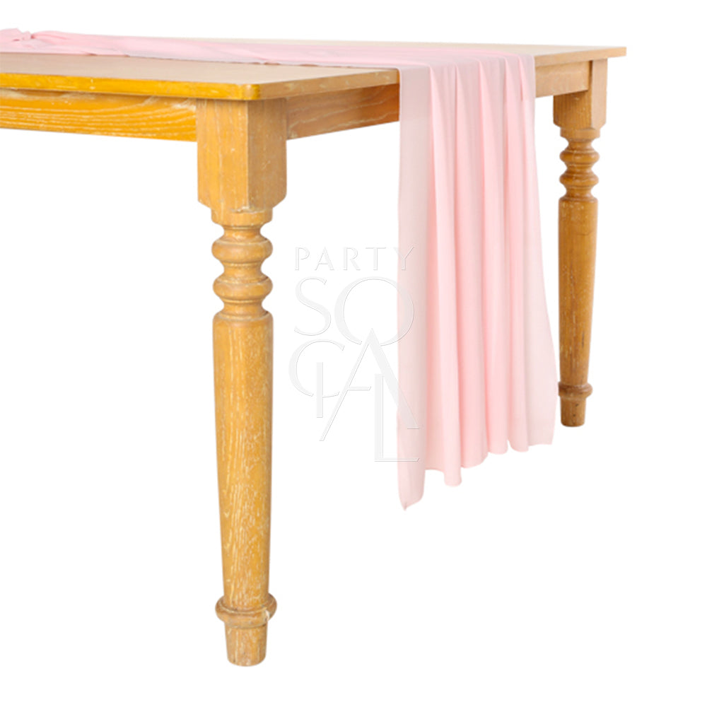 A chiffon table runner in soft pink, featuring a delicate and romantic design. This lovely runner adds a touch of warmth and charm to your table, perfect for enhancing special occasions and everyday meals.