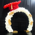 A graduation cap round balloon arch in white and red, featuring a celebratory and vibrant design. Made from durable plastic and metal, this arch adds a festive touch to graduation parties and ceremonies, creating a striking visual centerpiece.