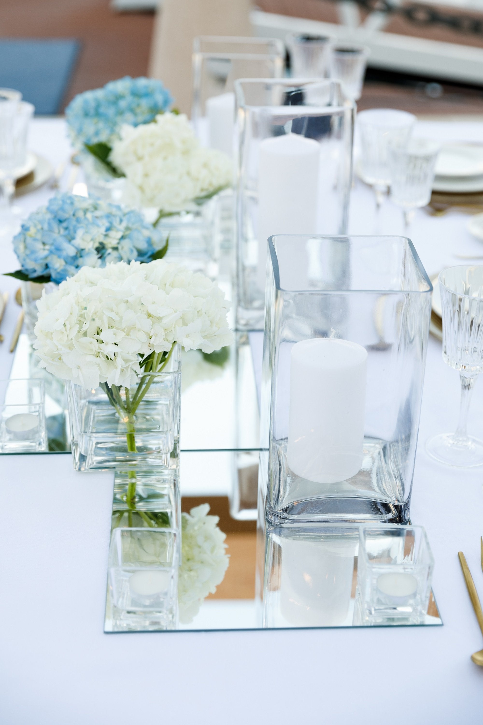 Modern square glass vases with a sleek, transparent design, featuring clean lines and a versatile shape. The vases are perfect for showcasing floral arrangements or decorative elements, adding a touch of contemporary elegance to any space.