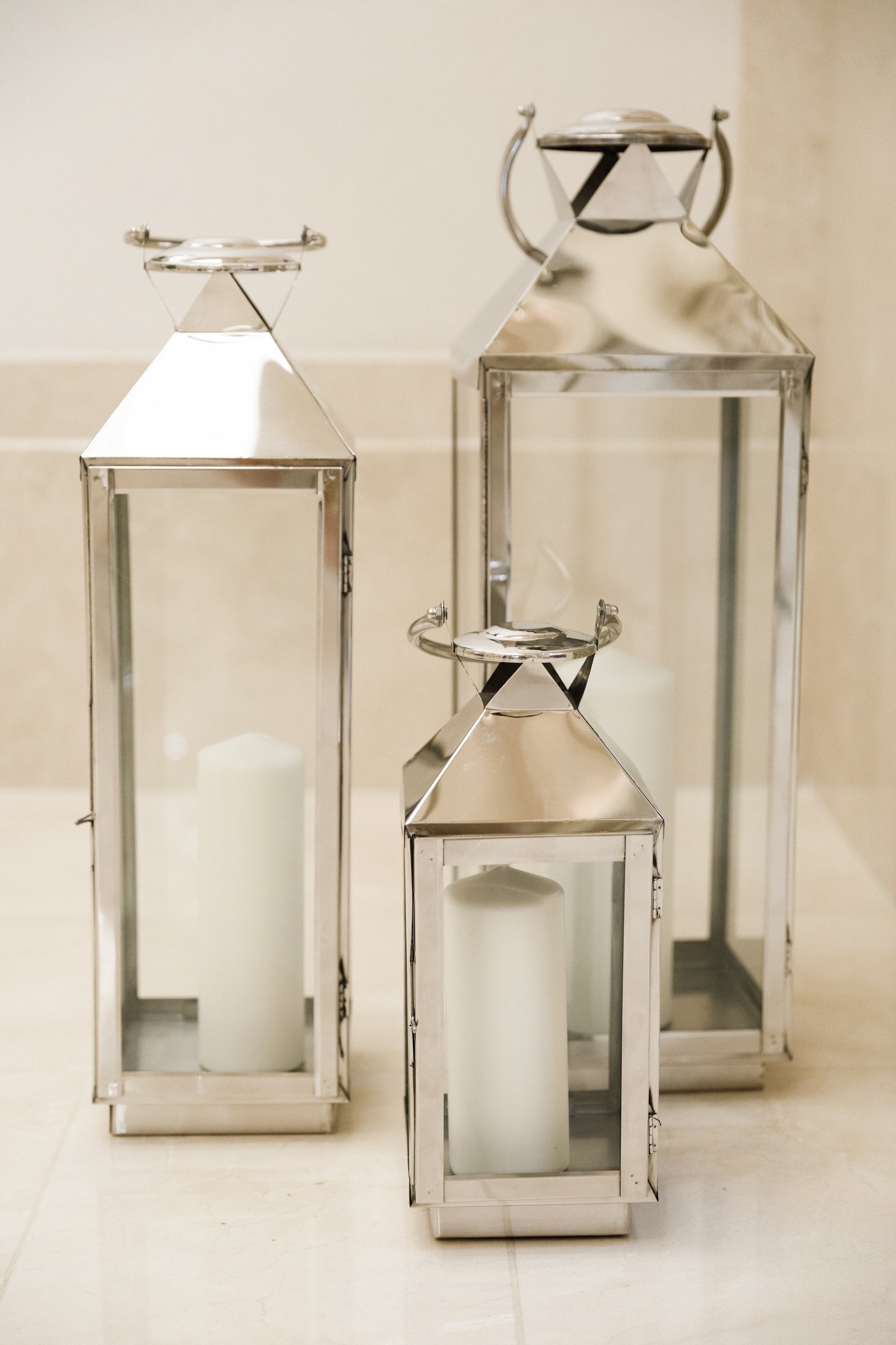 Elegant silver lanterns with a sleek, metallic finish and intricate detailing. The lanterns feature a classic design that adds a touch of sophistication and charm, perfect for illuminating and enhancing any indoor or outdoor setting.