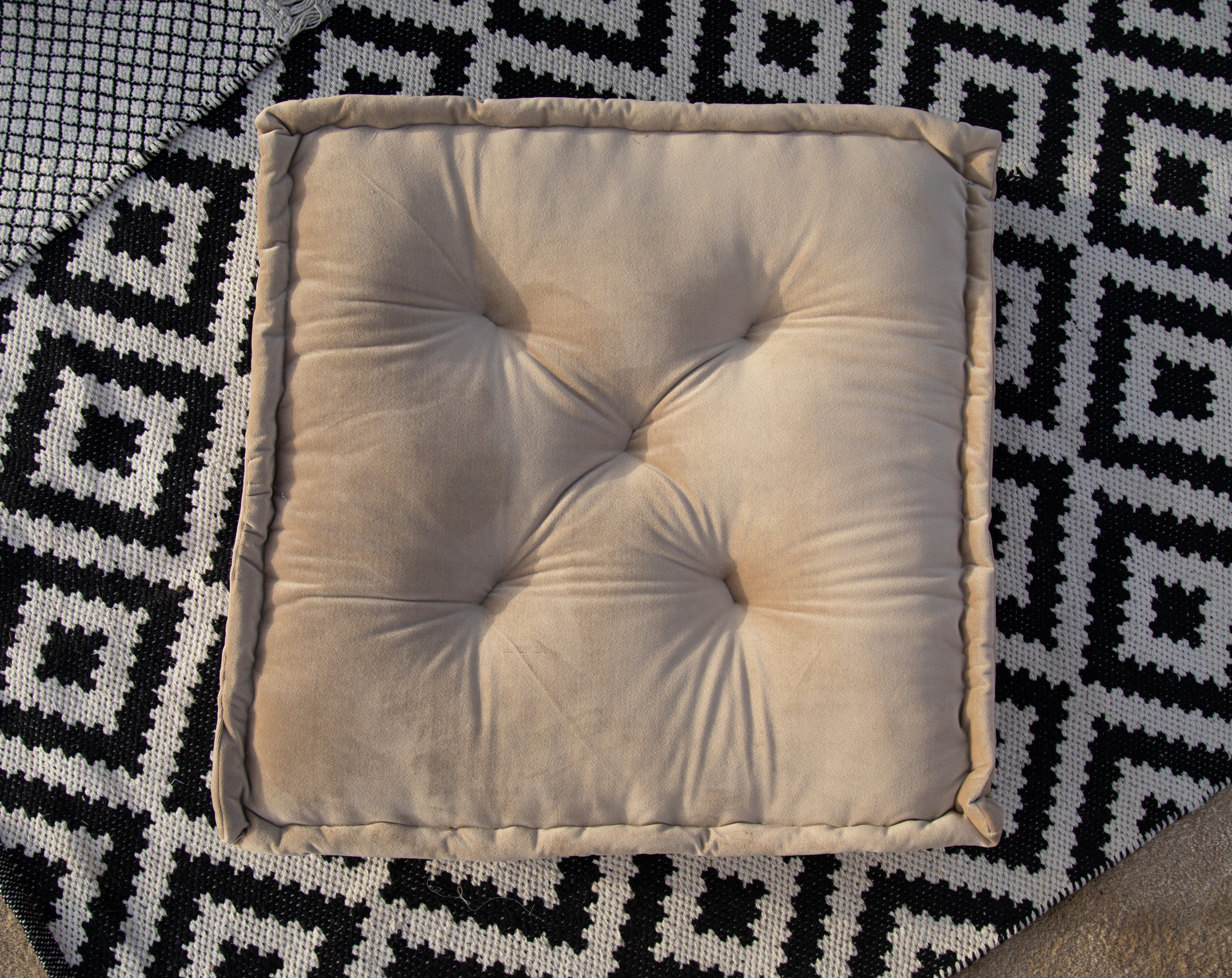 Elegant floor cushion in soft sand velvet, showcasing a smooth and plush texture. The neutral sand color adds a warm and subtle touch, making it a versatile and refined addition to any room or decor.