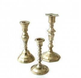 Set of three brass candlesticks, each with a classic, polished finish and designed to hold taper candles, perfect for adding a touch of elegance and warmth to any table or mantel.