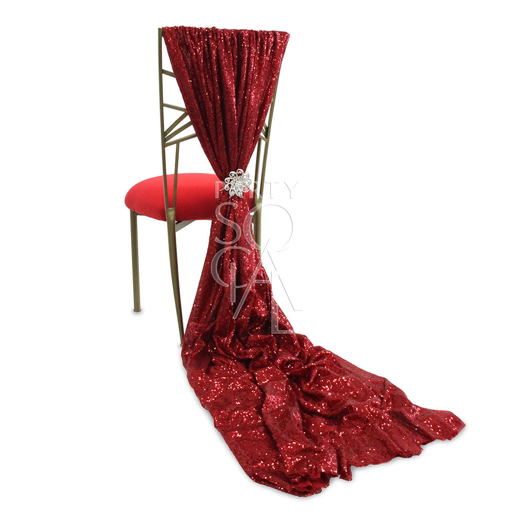 Red sequin chair cover designed for Chameleon chairs, featuring a shimmering sequin fabric that creates a sparkling effect. The cover includes a train extension for added elegance and sophistication, enhancing the visual appeal of the chair.