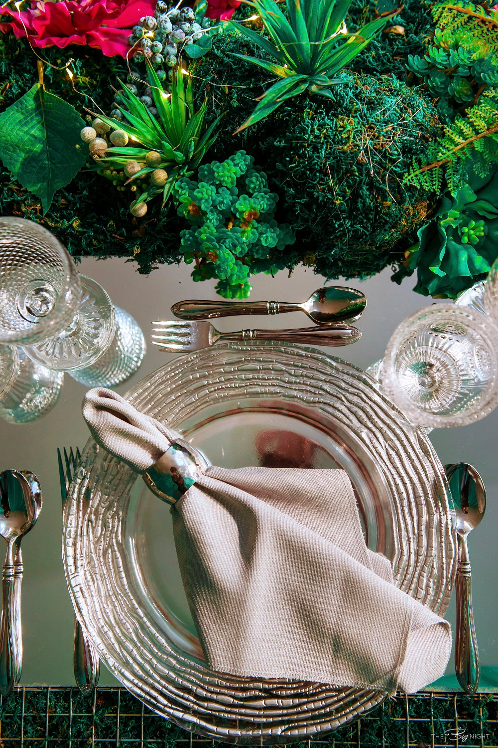 Glass charger plate with a silver ruffled edge, featuring a shimmering and elegant design that adds a touch of sophistication to any table setting.