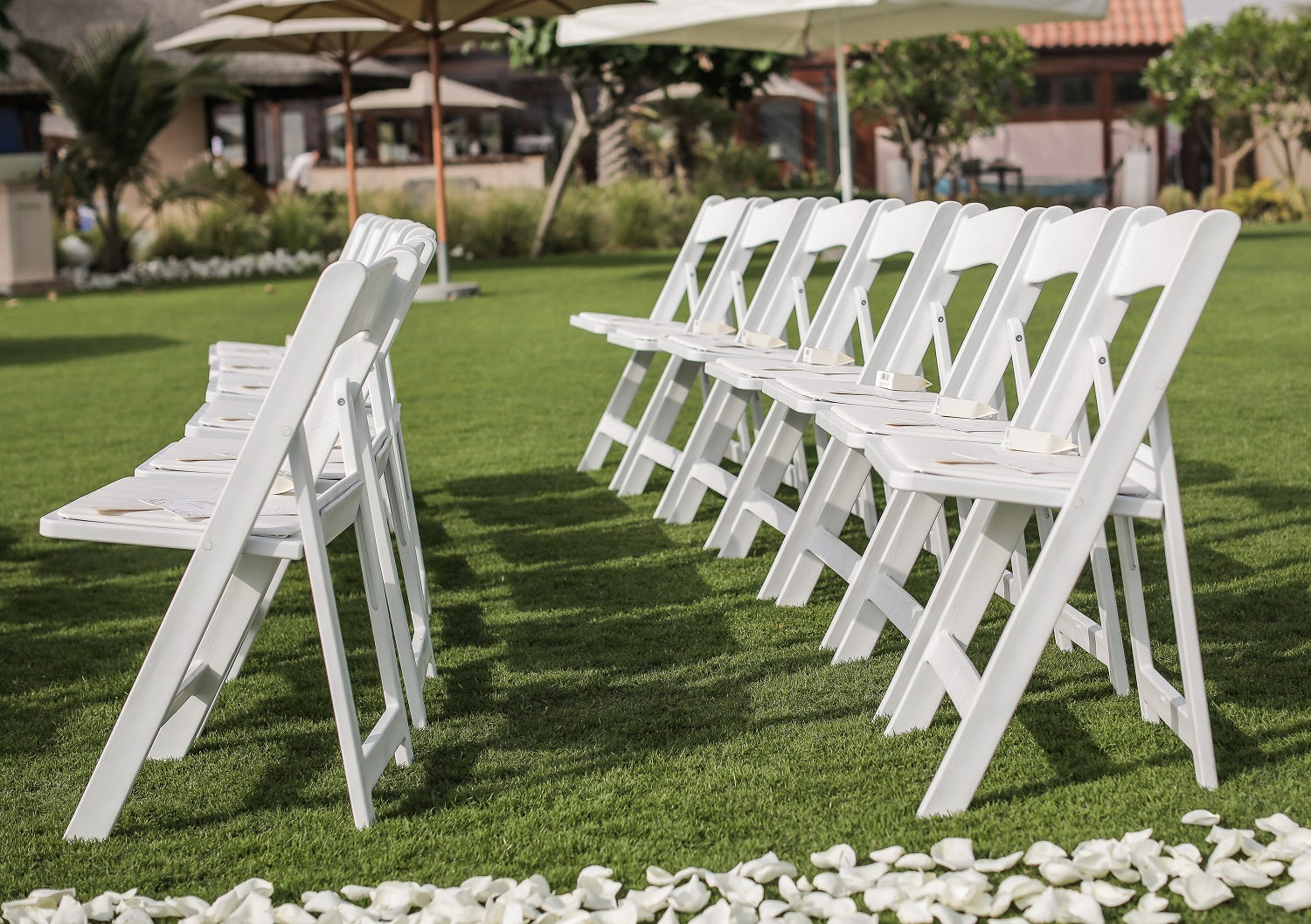 White garden chair with a classic design, featuring a slatted backrest and seat for comfort and ventilation. The chair is made from weather-resistant material, ideal for outdoor use.