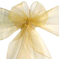 Luxurious organza chair sash in gold, showcasing a sheer, sparkling texture. The gold color adds a glamorous and opulent touch, ideal for elevating the style of any event or decor.