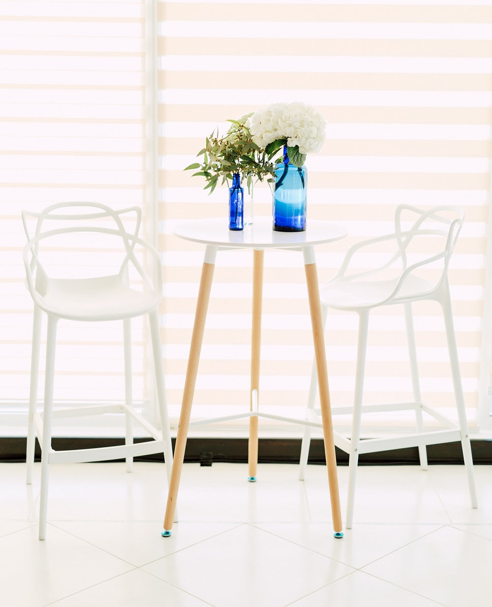 Eames replica cocktail table with a sleek, mid-century modern design. Features a round glass top with a minimalist white base and chrome legs. A stylish and functional addition to contemporary interiors.
