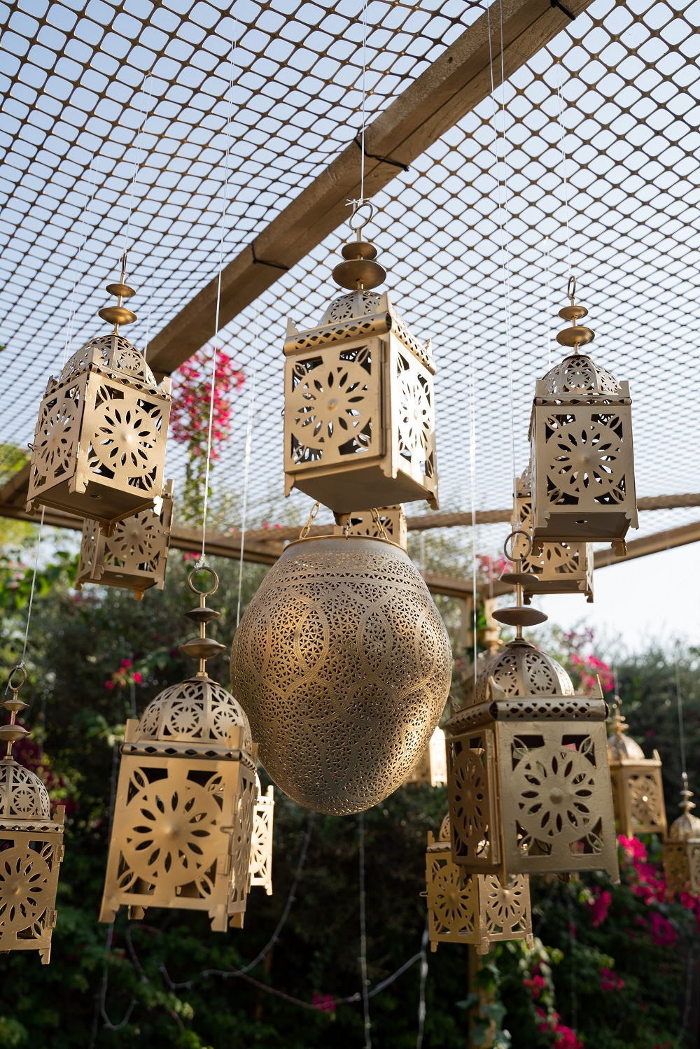 An intricately designed vintage Arabic lantern with a rich gold finish. The lantern features ornate geometric patterns and detailed metalwork, creating a warm, ambient glow when lit. Its classic design includes a hinged door for easy access to the candle or light source inside.