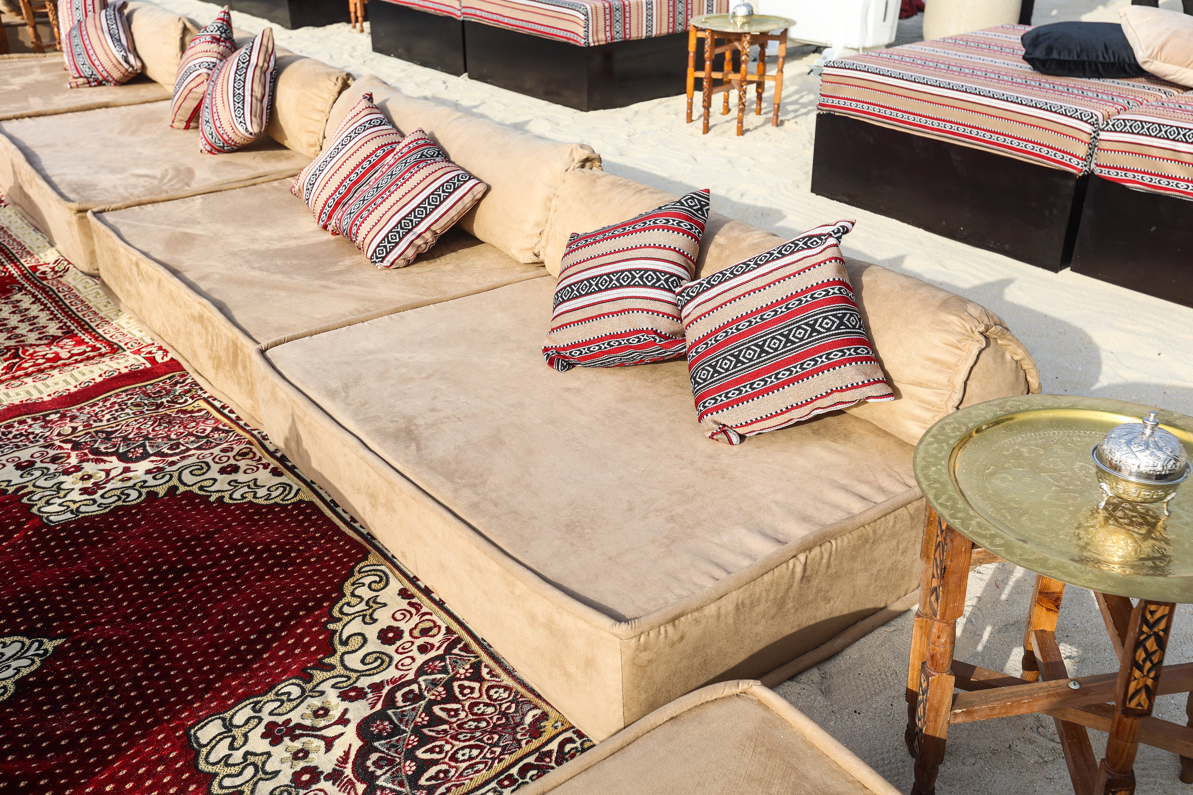 Spacious and modern lounge low seating arrangement featuring plush cushions and a sleek, low-profile design. The seating area includes a combination of modular pieces with soft upholstery in a neutral color palette, ideal for creating a comfortable and stylish relaxation space in contemporary living areas