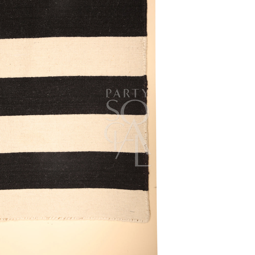 Chic rug with a classic black and white striped pattern, featuring alternating bold stripes that create a striking contrast. The rug’s clean, geometric design adds a modern and stylish touch to any room, enhancing both contemporary and minimalist decor themes.