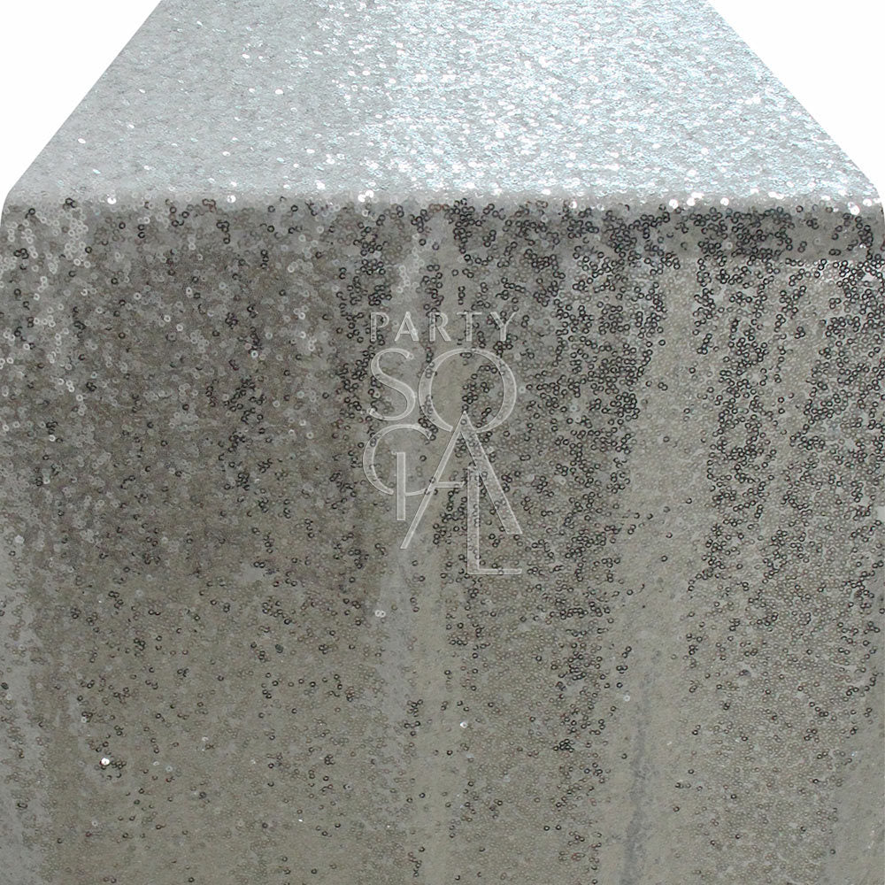 Glamorous sequin table runner in a shimmering silver color, featuring a sparkling surface that catches the light beautifully. The silver sequins add a touch of modern elegance and sparkle, perfect for enhancing any dining table or special event decor.