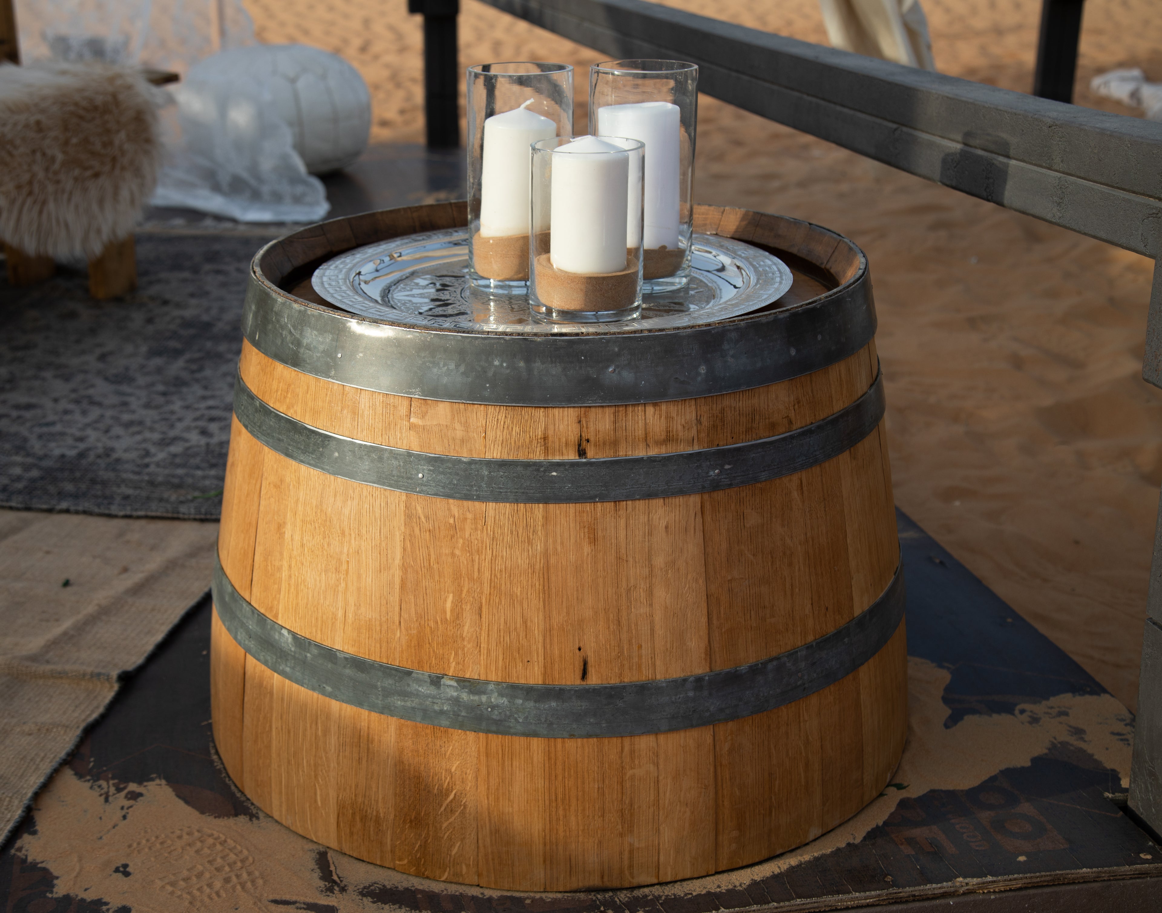 Rustic half wine barrel table with a weathered wood finish. Features a round top made from a repurposed wine barrel, complete with metal bands for an authentic vintage look. Perfect for adding a touch of rustic charm to any space.