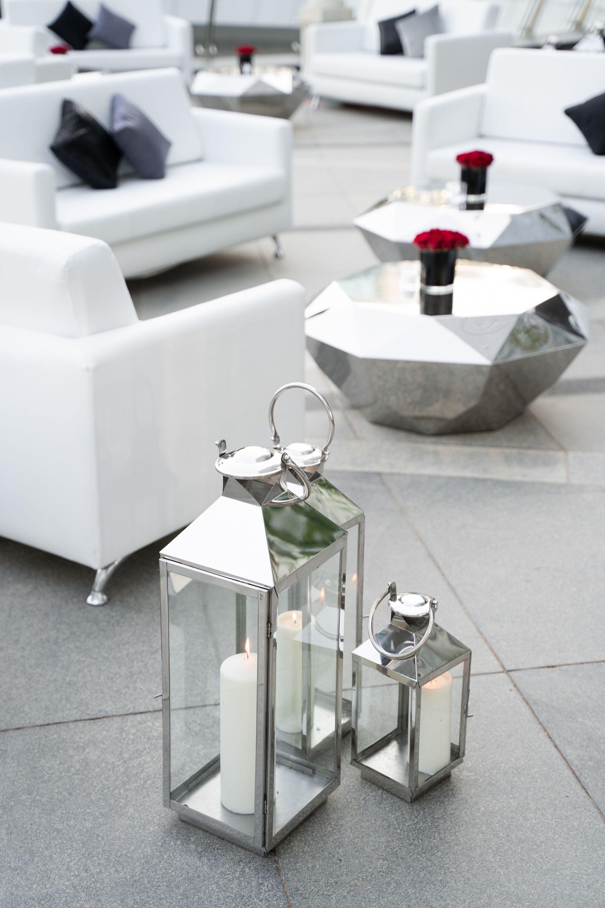 Elegant silver lanterns with a sleek, metallic finish and intricate detailing. The lanterns feature a classic design that adds a touch of sophistication and charm, perfect for illuminating and enhancing any indoor or outdoor setting.