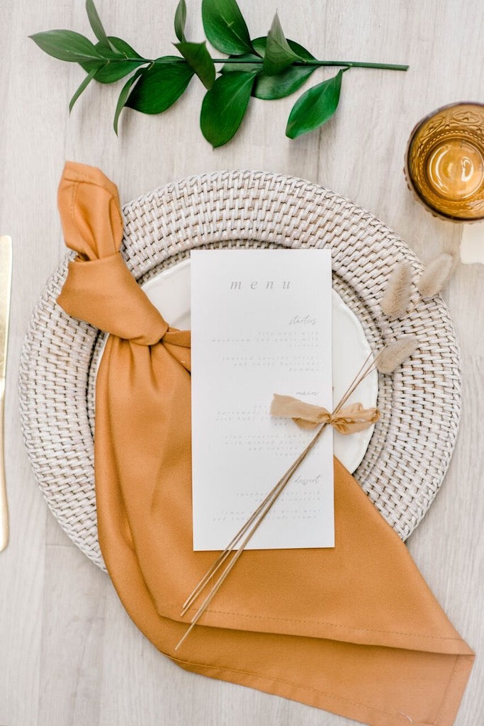 Rattan charger plate with a white wash finish, featuring a distressed and airy look. The white wash rattan adds a rustic yet elegant touch, ideal for a coastal or vintage-inspired table setting.