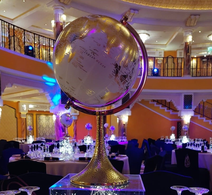 Elegant globe centerpiece featuring a stylish, decorative design. The globe is mounted on a sleek base and showcases intricate details, making it a sophisticated focal point for any table or event. Its classic and refined appearance adds a touch of global charm and sophistication to any setting.