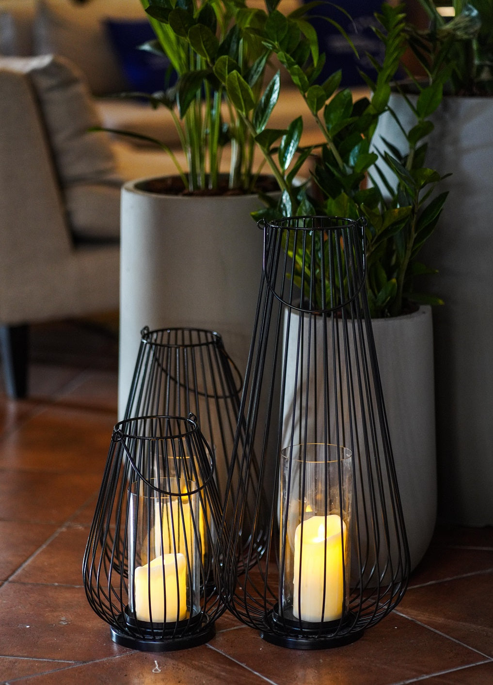 Stylish black wire lanterns with a geometric design, featuring a sleek, open-frame construction that casts intricate shadows when illuminated. The black metal wire adds a contemporary touch, making these lanterns a chic and versatile addition to any indoor or outdoor space.