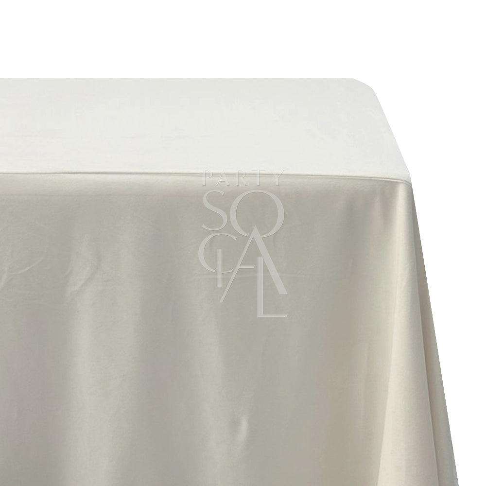 A rectangular velvet tablecloth in a soft cream color, made from a cotton/linen blend. This luxurious tablecloth adds a touch of elegance and warmth to your dining area with its plush texture and refined appearance.