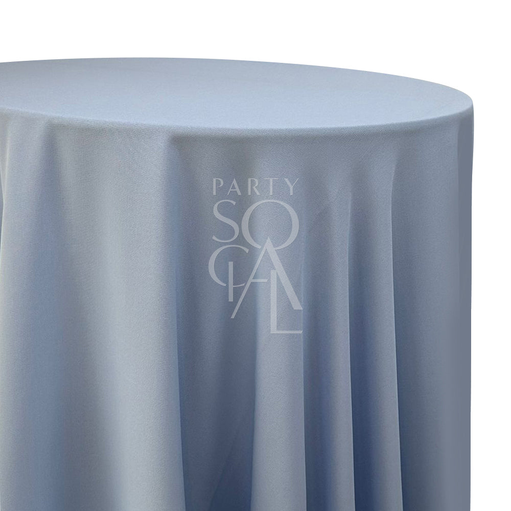 Round cotton linen tablecloth in dusty blue, featuring a muted and serene hue. The dusty blue color adds a calm and sophisticated touch, perfect for a tranquil and refined table setting.