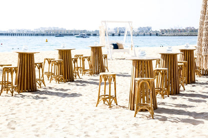 A wooden cocktail table featuring a sleek and modern design. This stylish table has a sturdy wooden construction, perfect for holding drinks and appetizers during gatherings and events. Ideal for adding a touch of rustic elegance and functionality to any bar area, lounge, or event space.