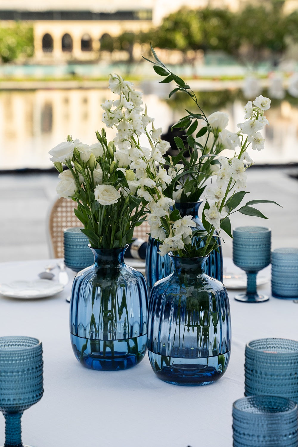 A cylindrical glass vase in vibrant blue, featuring a sleek and elegant design. The blue glass adds a pop of color and a touch of sophistication, making it a stylish centerpiece for floral arrangements or decorative accents in any space.