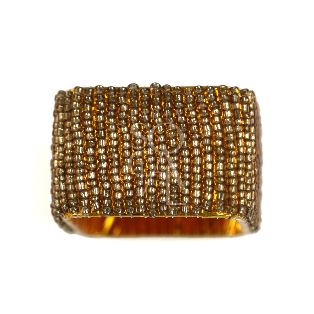 A gold beaded napkin ring featuring a stylish and elegant design. This napkin ring is adorned with small, gleaming gold beads arranged in a sophisticated pattern, adding a touch of luxury and refinement to your table setting. Ideal for enhancing the presentation of napkins at formal dinners, special occasions, or elegant gatherings.