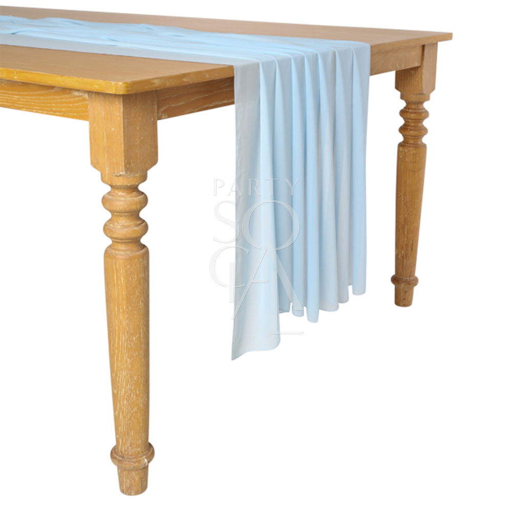 A chiffon table runner in gentle light blue, with a soft and flowing appearance. This charming runner adds a touch of serenity and elegance to your table setting, ideal for both casual and elegant gatherings.