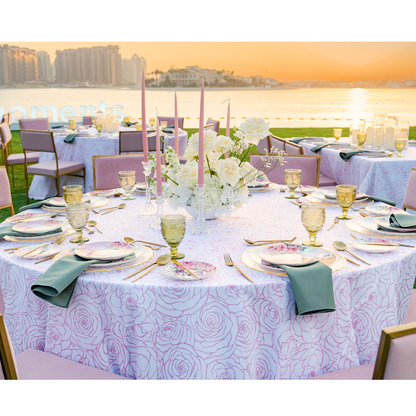 A round tablecloth in pink featuring a charming floral pattern. This elegant tablecloth adds a touch of sophistication and warmth to your dining setting, ideal for both casual meals and special occasions. The soft pink color and floral design create a delightful and inviting atmosphere.