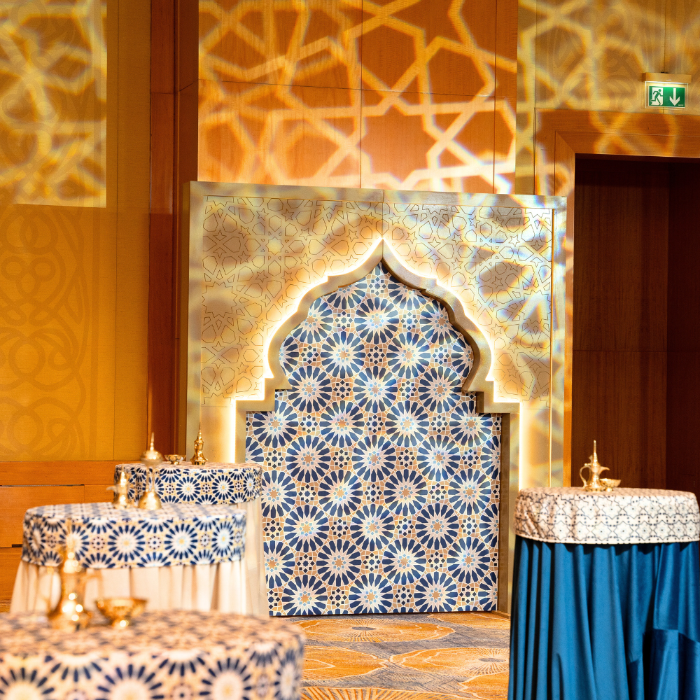 A beautifully designed Arabic-style arch featuring ornate patterns and glowing LED lights, offered for rent. The arch is lit with a warm, inviting glow, highlighting its intricate details and elegant curves.