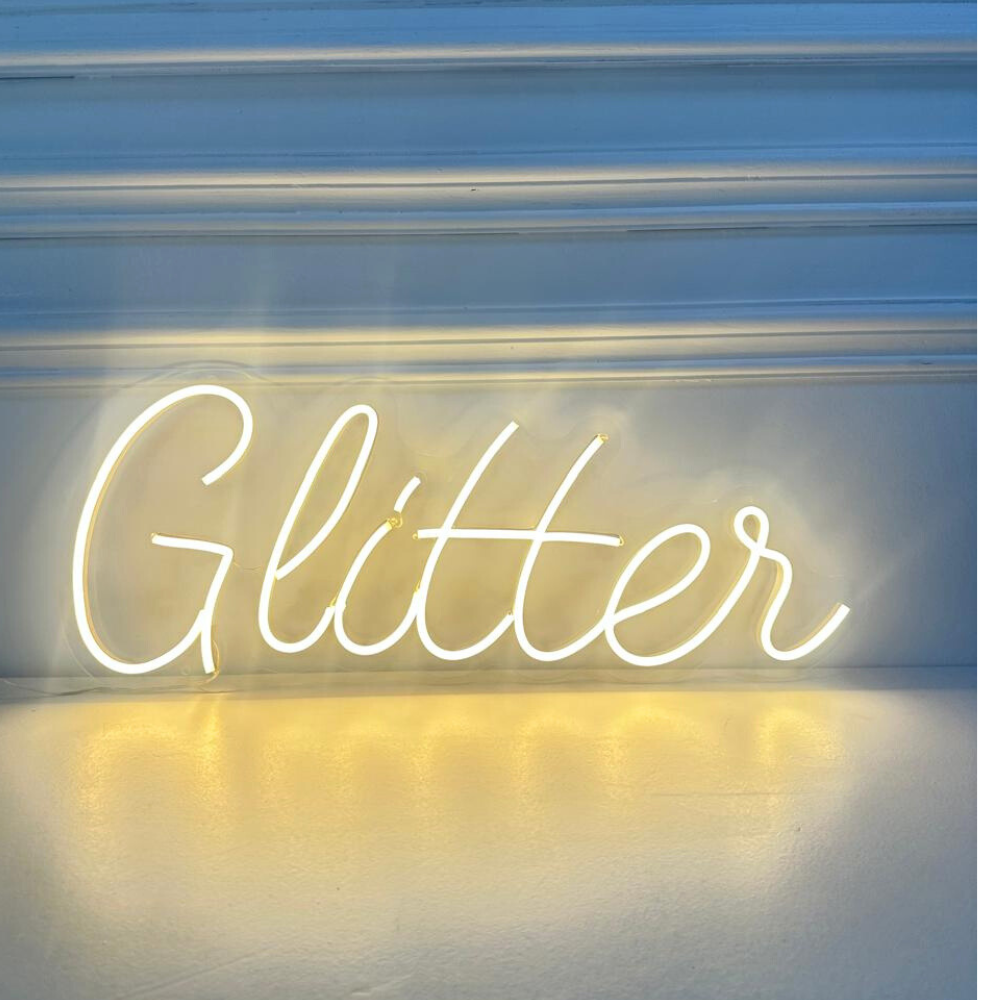 A &quot;Glitter&quot; LED neon sign in white, featuring a bright and elegant design. AC powered, this sleek sign is suitable for indoor use, perfect for adding a touch of sparkle and sophistication to parties, events, and home decor.